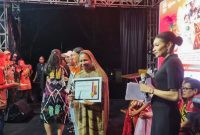 Ketua TP PKK Deiyai, Fransina Rumbiak Mote, S.K.M., menerima penghargaan juara umum bersama tim dalam Festival TIFA 2025 di Timika, Papua Tengah.