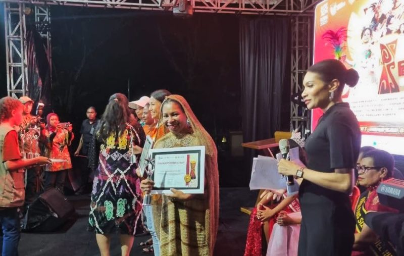Ketua TP PKK Deiyai, Fransina Rumbiak Mote, S.K.M., menerima penghargaan juara umum bersama tim dalam Festival TIFA 2025 di Timika, Papua Tengah.