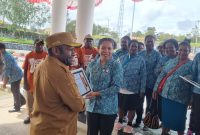 Ketua TP PKK Kabupaten Deiyai menyerahkan Piagam penghargaan atas peraihan juara umum, Juara 2 Pakaian adat, dan Talingkar Cinta di ajang Festival Tifa di Timika 2025.