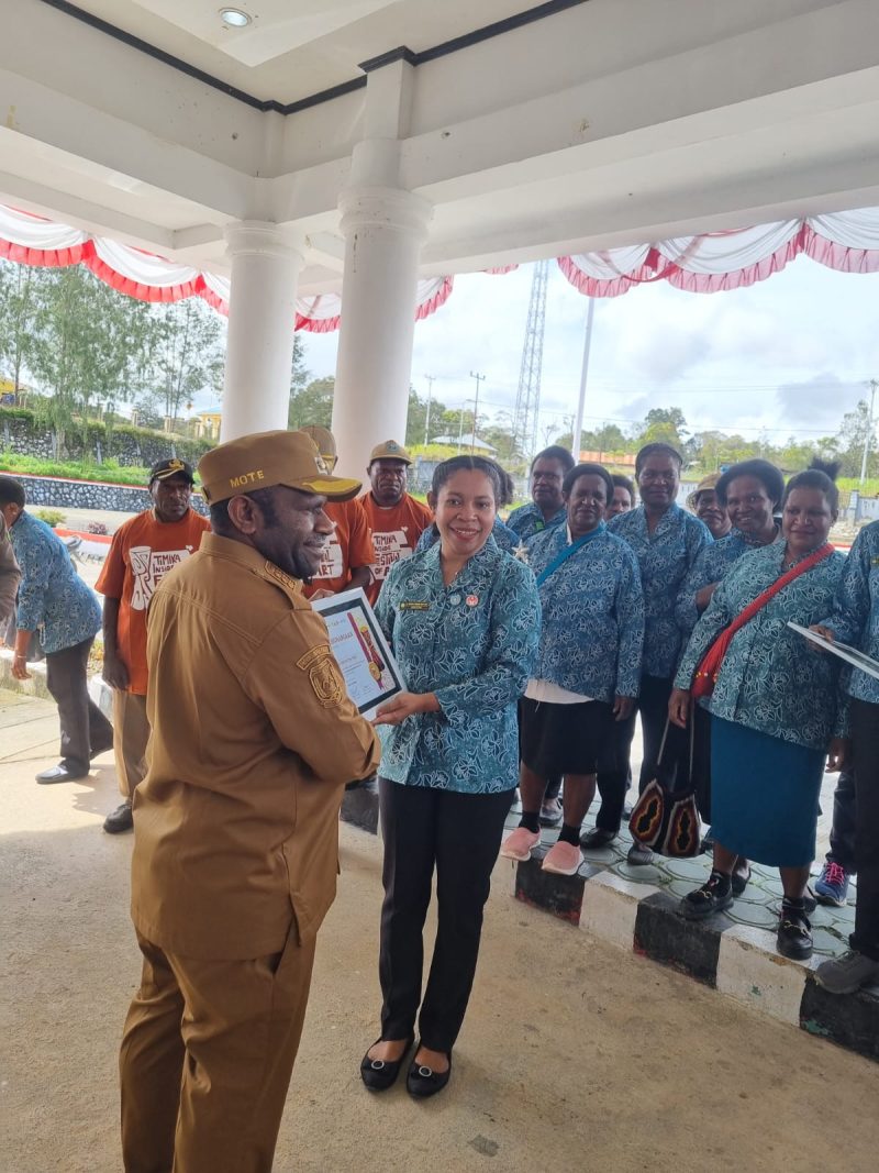 Ketua TP PKK Kabupaten Deiyai menyerahkan Piagam penghargaan atas peraihan juara umum, Juara 2 Pakaian adat, dan Talingkar Cinta di ajang Festival Tifa di Timika 2025.