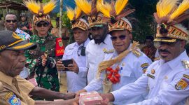 Bupati Puncak Elvis Tabuni menyerahkan dana desa secara langsung kepada kepala kampung di Distrik Dorvos, disaksikan Ketua DPRD dan jajaran OPD.