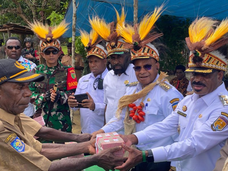 Bupati Puncak Elvis Tabuni menyerahkan dana desa secara langsung kepada kepala kampung di Distrik Dorvos, disaksikan Ketua DPRD dan jajaran OPD.