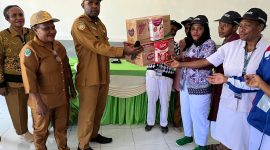 Kepala DP3AKB Deiyai, Robby Bobii, S.Ip menyerahkan secara simbolis Susu SGM kepada perwakilan petugas Puskesmas dari lima distrik dan RSUD Pratama Waghete.