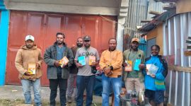 Angginak Sepi Wanimbo bersama rekan menyerahkan buku bacaan kepada Ketua Komunitas Weneninu, Erik Tabuni, di Sinakma, Wamena (17/8/2025).