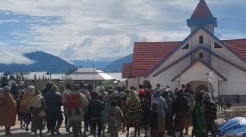 Warga Bomou saat menyerahkan sumbangan sukarela untuk peresmian Gereja Kingmi Kalvari Bomou II. Kebersamaan dan gotong royong menjadi semangat utama dalam mendukung pembangunan gereja.
