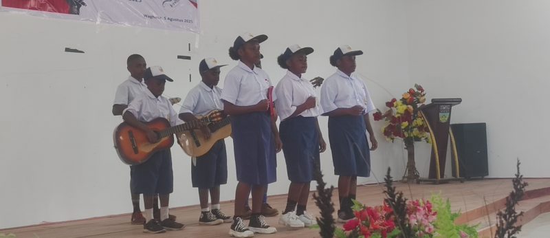 Siswa SMP YPPGI Tenedagi saat memainkan gitar melodi dalam lomba vokal grup tingkat SMP dan SMA/SMK Kabupaten Deiyai, 5 Agustus 2025. Aksinya memukau penonton dan juri berkat teknik bermain yang halus dan penuh karakter.