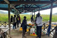 Bupati Paniai, Yampit Nawipa (tengah), memimpin penyaluran bantuan beras untuk warga terdampak banjir di Distrik Paniai Barat dan Distrik Deyaimiyo.