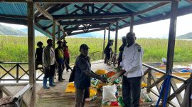Bupati Paniai, Yampit Nawipa (tengah), memimpin penyaluran bantuan beras untuk warga terdampak banjir di Distrik Paniai Barat dan Distrik Deyaimiyo.