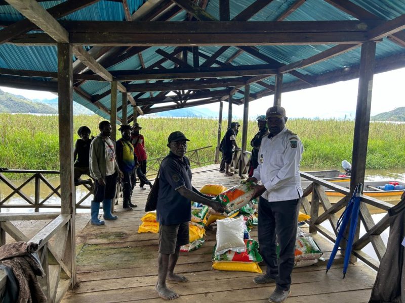 Bupati Paniai, Yampit Nawipa (tengah), memimpin penyaluran bantuan beras untuk warga terdampak banjir di Distrik Paniai Barat dan Distrik Deyaimiyo.