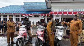 Bupati Melkianus Mote menyerahkan 3 unit motor kepada Yesaya Edowai, Amison Kotouki, dan Hans Edowai, para pemenang lomba panjat pinang HUT RI ke-80 di Kabupaten Deiyai. 