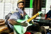 "Senior Edowai, gitaris otodidak asal Deiyai yang memulai karier musik sejak usia 8 tahun dengan gitar Kapok, tetap lincah dan inspiratif hingga tahun 2025."