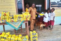 Maria Doo, S.Pd tampak membagikan seragam sekolah kepada siswa-siswi SD YPPK Damabagata. 