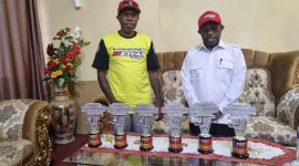 Pengurus IMI Deiyai, John Mote, menyerahkan trofi Juara Umum ke-2 Kejurnas Motoprix kepada Bupati Deiyai, Melkianus Mote.