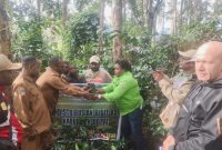 Kepala Dinas Pertanian Kabupaten Deiyai Aleks Pigai (kanan) bersama perwakilan Dinas Pertanian Provinsi, Ibu Maya (tengah), menyerahkan 6.400 bibit kopi secara simbolis kepada Bupati Deiyai Melkianus Mote (kiri).