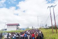 Ratusan Anak Sekolah Minggu Koordinator Deiyai Gereja Kingmi memegang papan bertuliskan cita-cita mereka saat Longmarch Pawai Damai di Kota Waghete, Jumat (17/10/2025).