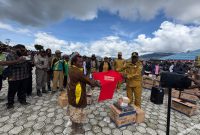Kepala Dinas Perikanan dan kelautan Marius Pakage sedang menyerahkan peralatan Perikanan kepada salah seorang Ibu di halaman kantor bupati Deiyai pada 4/11/2025. 