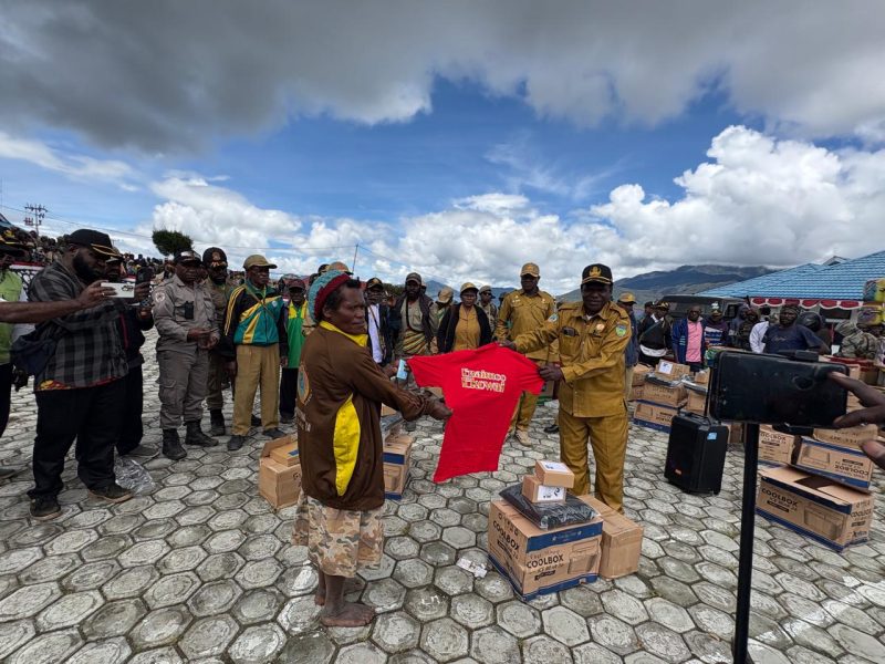 Kepala Dinas Perikanan dan kelautan Marius Pakage sedang menyerahkan peralatan Perikanan kepada salah seorang Ibu di halaman kantor bupati Deiyai pada 4/11/2025. 