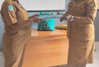 Pebur Mote (kiri) secara resmi menyerahkan berkas administrasi kepada Linda Agapa (kanan) dalam momen serah terima jabatan Sekretaris RSUD Deiyai, Selasa (4/11/2025).