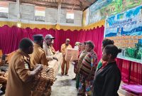 Disperindag Burno Adii di dampingi kepala bidang dan staff, menyerahkan secara simbolis alat dan bahan produksi kue kepada perwakilan pelaku usaha Orang Asli Papua (OAP) di Aula Gereja Katolik Waghete, Senin (27/01/2025).
