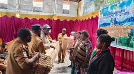 Disperindag Burno Adii di dampingi kepala bidang dan staff, menyerahkan secara simbolis alat dan bahan produksi kue kepada perwakilan pelaku usaha Orang Asli Papua (OAP) di Aula Gereja Katolik Waghete, Senin (27/01/2025).
