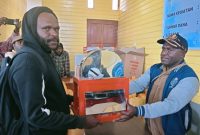 Kepala Dinas KETAPANG Melianus sedang menyerahkan Mesin pelet kepada salah seorang  pemuda pada 11/11/2025. 