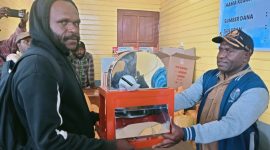 Kepala Dinas KETAPANG Melianus sedang menyerahkan Mesin pelet kepada salah seorang  pemuda pada 11/11/2025. 