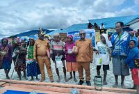 Bupati Deiyai, Melkianus Mote, (kiri) menyerahkan bahan bangunan secara simbolis kepada salah seorang janda/duda di Halaman Kantor Bupati Deiyai, Selasa (18/11).