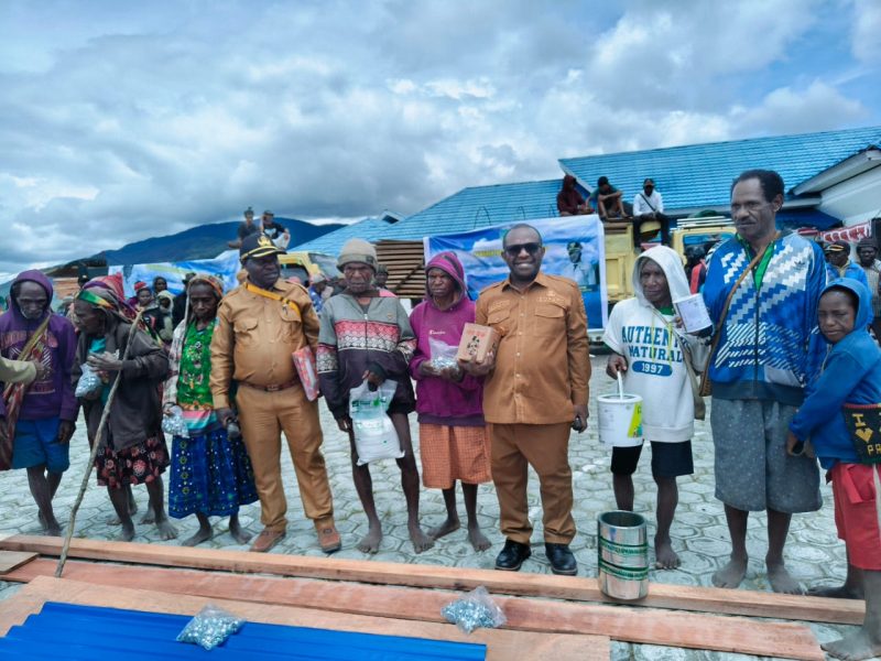 Bupati Deiyai, Melkianus Mote, (kiri) menyerahkan bahan bangunan secara simbolis kepada salah seorang janda/duda di Halaman Kantor Bupati Deiyai, Selasa (18/11).