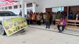 Kepala Dinas Pertanian Kabupaten Deiyai, Aleks Pigai, M.Pd., menyerahkan paket bantuan beragam bibit tanaman dan pupuk kepada perwakilan masyarakat di halaman kantor bupati, Kamis (20/11/2025). 