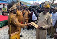 Bupati Deiyai, Melkianus Mote, menyerahkan penghargaan kepada Ketua Tim Pemekaran Kabupaten Deiyai, Mesak Pakage (kanan), yang dikenal sebagai 