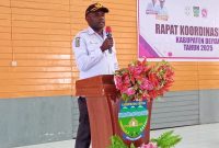 Robby Bobii, Kepala DP3AKB Kabupaten Deiyai, menyampaikan sambutan dan arahan dalam Rapat Koordinasi Tim Percepatan Penurunan Stunting (TPPS) di Aula Sekwan, Rabu (10/12/2025).