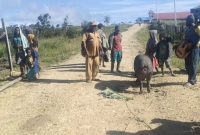 Kepala Desa Kokobaya, Marianus Pinibo, saat menyerahkan bantuan secara simbolis kepada warga dalam rangkaian kegiatan Berbagi Kasih menyambut Natal 2025.