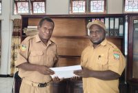 Daniel Bunai, SE., ST (kanan) saat melakukan serah terima jabatan Kepala Bagian Humas Kabupaten Deiyai kepada Yehezkiel Kotouki, SH., MH (kanan) di Kantor Sekretariat Daerah, Selasa (20/1/2026).