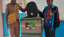 Sekretaris Dinas Pendidikan dan Pengajaran Kabupaten Deiyai, Marselus Bobii (tengah), menyerahkan secara simbolis paket perlengkapan sekolah kepada Kepala Sekolah SD YPPGI Idego, Selasa (10/2/2026).