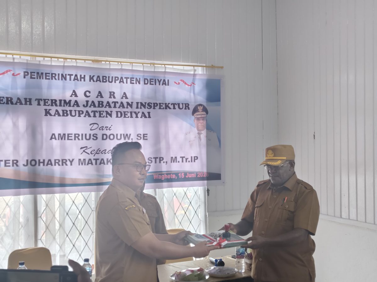 Amerius Douw, SE menyerahkan secara simbolis dokumen administrasi dan aset kantor kepada Kepala Inspektorat Kabupaten Deiyai yang baru, Peter Joharry Matakena, S.STP., M.Tr.IP, disaksikan Bupati Deiyai Melkianus Mote, S.T dan para pejabat daerah di Aula Inspektorat Kabupaten Deiyai, Senin (15/6/2026).
