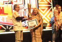 Ketua Dekranasda Kabupaten Deiyai, Fransina Rumbiak Mote, menunjukkan piala Juara Umum Festival Timika Inside Festival of Art (TIFA) 2026 yang berhasil diraih untuk kedua kalinya secara berturut-turut.