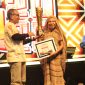 Ketua Dekranasda Kabupaten Deiyai, Fransina Rumbiak Mote, menunjukkan piala Juara Umum Festival Timika Inside Festival of Art (TIFA) 2026 yang berhasil diraih untuk kedua kalinya secara berturut-turut.