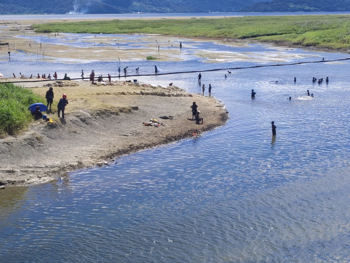 Masyarakat sedang mandi dan cuci baju di muara kali Oneibo di masa musim kemarau. 
