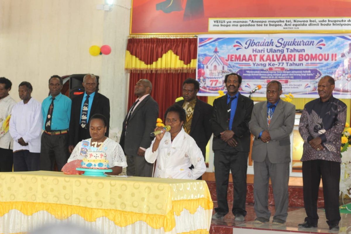 Prosesi pemotongan kue ulang tahun ke-77 Gereja KINGMI Jemaat Kalvari Bomou II yang dipimpin Alpince Pakage dan Irence Dogopia, sebagai simbol syukur dan kebersamaan antara gereja dan pemerintah.
