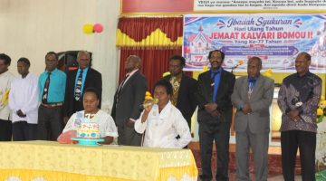 Prosesi pemotongan kue ulang tahun ke-77 Gereja KINGMI Jemaat Kalvari Bomou II yang dipimpin Alpince Pakage dan Irence Dogopia, sebagai simbol syukur dan kebersamaan antara gereja dan pemerintah.